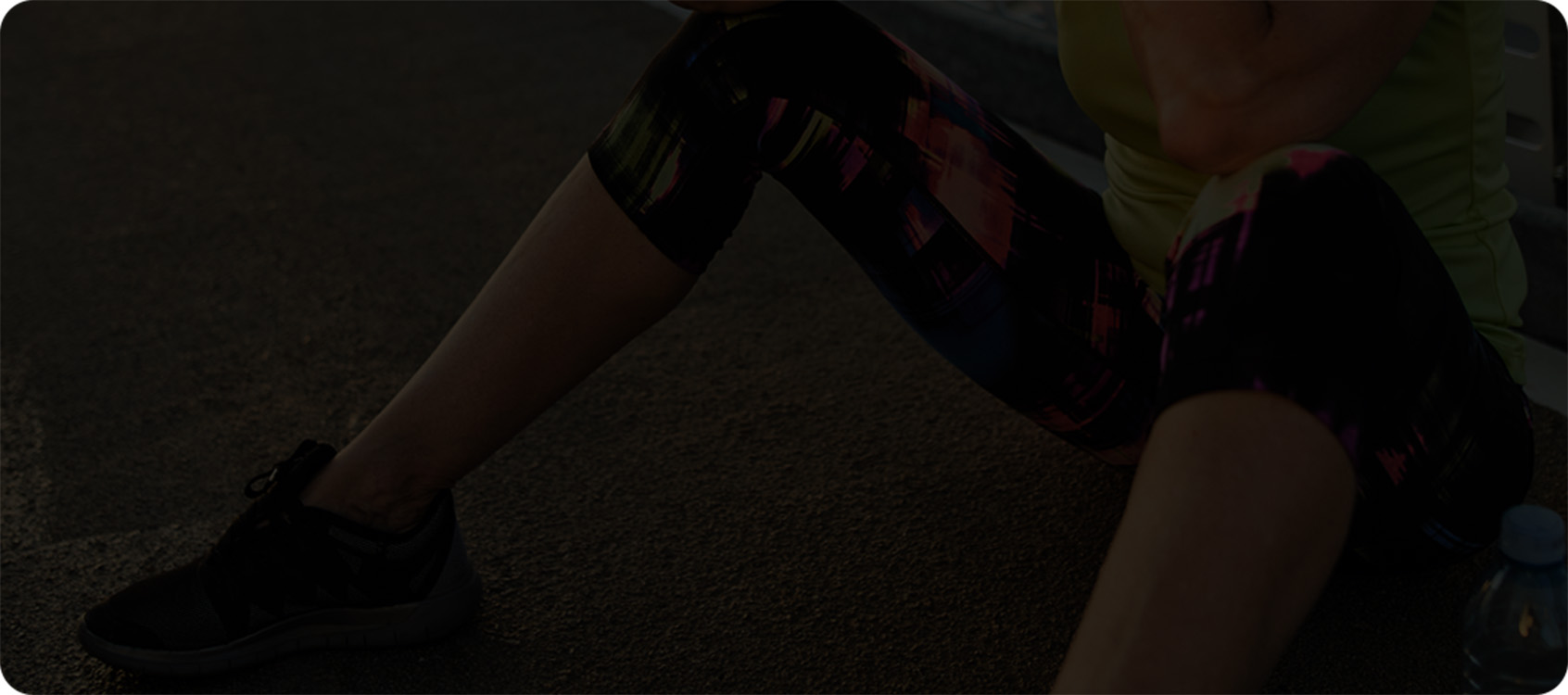 woman knees bent, sitting on the pavement